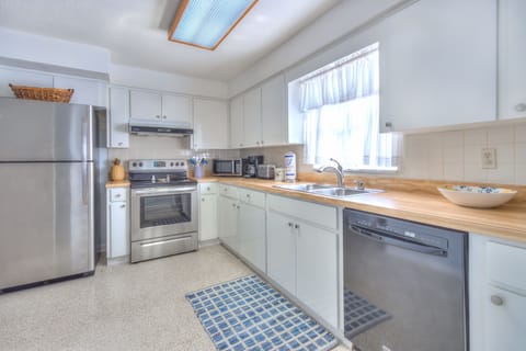Fully equipped kitchen with modern appliances and basic cooking equipment