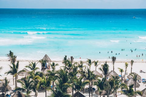 On the beach, white sand, beach cabanas, sun loungers
