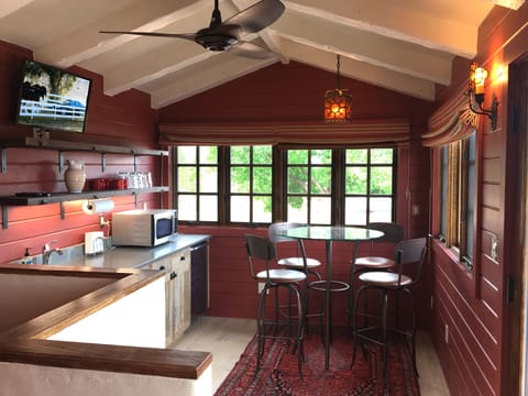 The “café” with flat screen TV, micro wave, sink, under counter fridge, table with bar stools and door to 2nd floor deck and sweeping Taos Mountain views