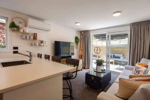 Relax in the bright living room with direct access to the outdoor patio. The perfect space for entertaining or unwinding, with easy flow between the indoors and the sunny, serene patio area.