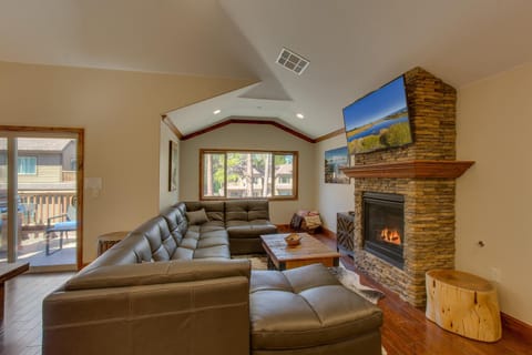 - Cozy living area with stone fireplace warmth  
- Mounted smart TV for streaming and movie nights  
- Large sectional seating for group relaxation