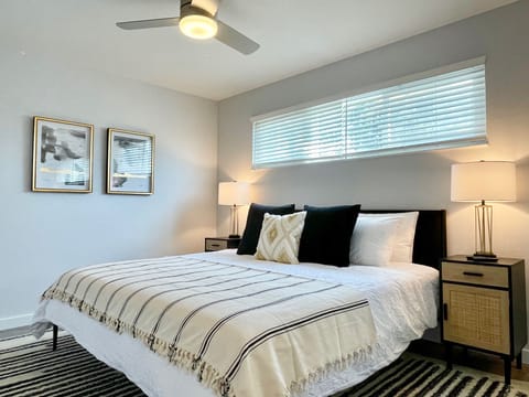King bedroom with dual nightstands, ambient lighting, and blackout shades