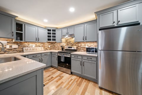 The open-concept kitchen has a gas stove, microwave, dishwasher, and fridge.