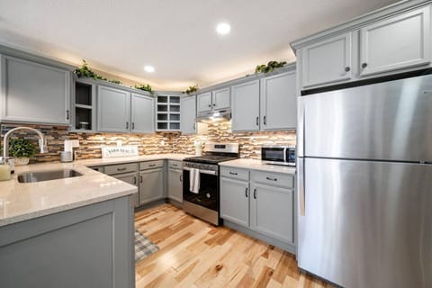 The open-concept kitchen has a gas stove, microwave, dishwasher, and fridge. It is fully stocked with all basic utensils. The  breakfast bar has three seats looking in to the kitchen.