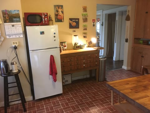 Kitchen w plethora of loose teas in card catalog, kettles on stove & electric