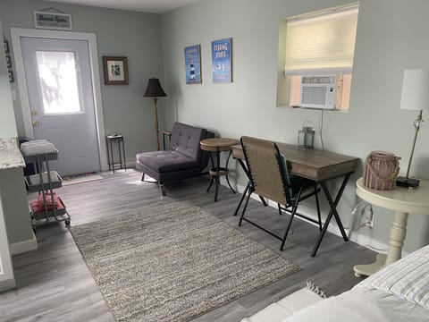 View from back of cottage looking at desk, bathroom door & front door entrance 