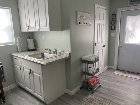 View from bed side of room looking at kitchenette, bathroom door and front door 