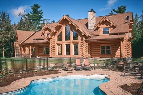 Stunning log cabin exterior with a private pool surrounded by nature