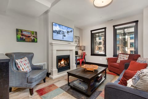 Living Room with 55" Samsung smart tv, plush furniture with sleeper-sofa, gas fireplace, and small work area