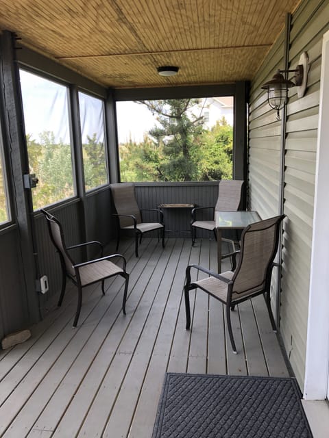 1st floor enclosed back deck with seating area.