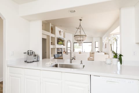 The fully equipped modern kitchen is stocked with all culinary essentials and breakfast bar seating.