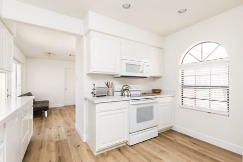 The fully equipped modern kitchen is stocked with all culinary essentials and breakfast bar seating.