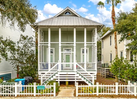 Coast Cottages East Beach Exterior - Elevated Coast Cottages home on East Beach, a two-minute walk to the ocean with front porch, white picket fence, and covered parking.