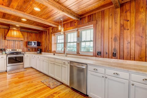 Spacious Fully Equipped Luxury Kitchen with Stainless Steel Appliances, A Large Butcher Block Island, Bar Stool Seating, and Beautiful Heart Pine Wood Walls and Beams