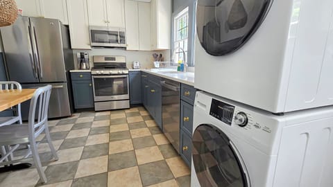 Kitchen has a stacked washer and dryer
