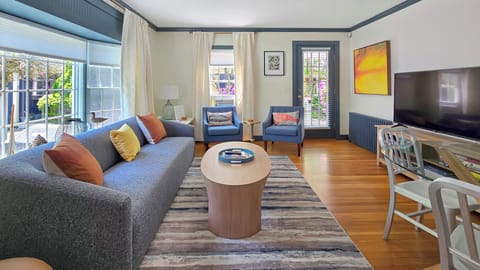 Living room has comfortable seating and a large flat screen smart TV