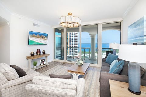 Relax in your bright living space with plush seating and stunning ocean views through floor-to-ceiling windows.