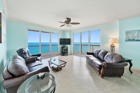 Relax in your oceanfront living room with stunning sea views through floor-to-ceiling windows. Comfortable leather seating invites you to unwind.