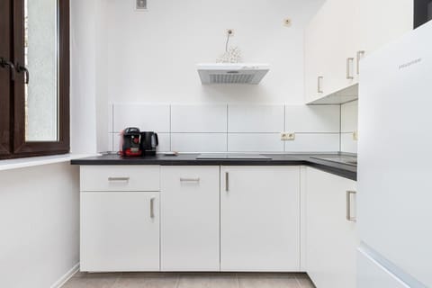 Functional kitchenette space with hob, fridge and dishwasher.