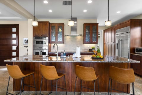 Pull up a seat at the breakfast bar in this gourmet kitchen featuring high-end finishes and custom lighting.