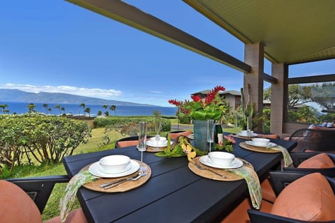 Spacious oceanview lanai with dining table, cushioned seating, and panoramic views.