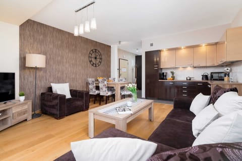  A large living area featuring comfortable sofas, a coffee table, and wooden flooring, accented with decor.