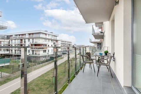 A balcony with wooden railings, offering a view of the surrounding area and modern buildings.
