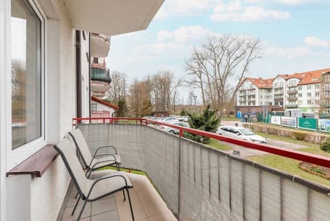 A balcony view showcasing outdoor seating and a pleasant view of neighboring buildings and greenery.