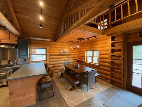 A large dining table to enjoy family meals. Above is a loft with two twin beds for extra guests.
