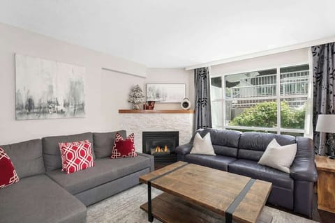 Cozy living area with gas fireplace and large windows overlooking the garden