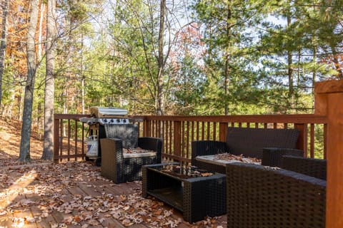 Spacious deck w/ outdoor seating, surrounded by tall trees & peaceful wooded views