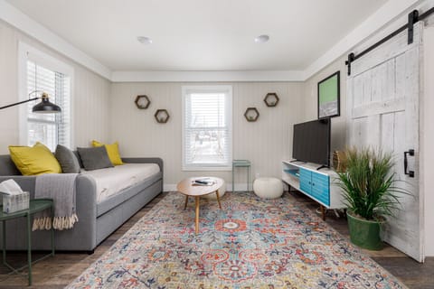 Bright living room w/ cozy sofa, patterned rug & TV wall for relaxed movie nights
