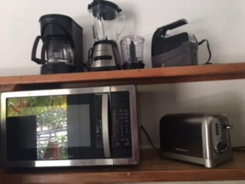 An array of small appliances, dishes, utensils make for a well-stocked kitchen.