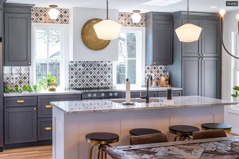 Contemporary kitchen featuring an island with four seats, elegant cabinets, and modern appliances. Ideal for casual dining or entertaining in style.