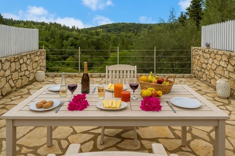 Inviting Terrace Dining Area with Scenic Views
Enjoy meals or evening drinks on the private terrace while taking in the serene views of the lush green surroundings and the sea in the distance.