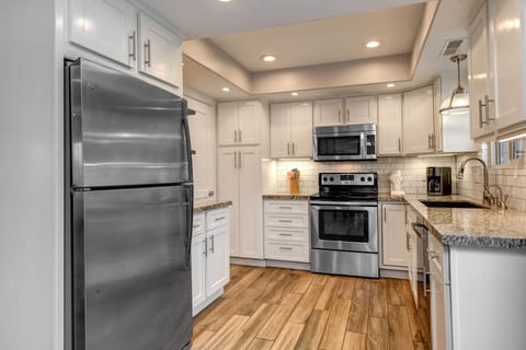 Fully Equipped Kitchen with stone countertops, stainless steel whirlpool appliances, and private patio access