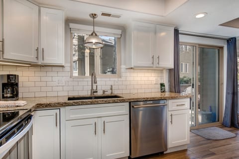 Fully Equipped Kitchen with stone countertops, stainless steel whirlpool appliances, and private patio access