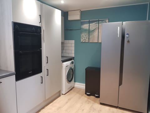 utility area with washer/drier. Large fridge freezer