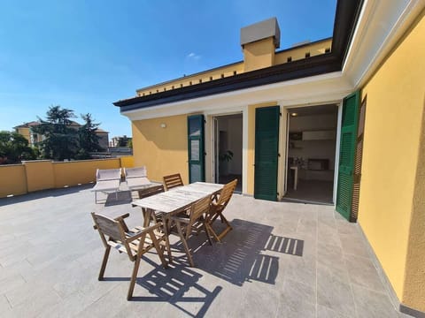 ampio terrazzo privato con tavolo, sedie a sdraio e ombrellone