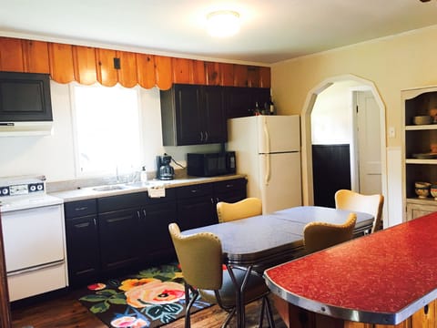 Eat in kitchen with mid-century table & chairs and red formica island