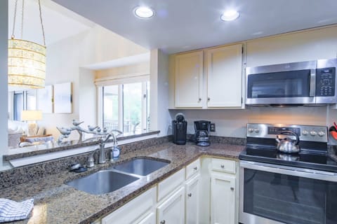 The kitchen features stainless steel appliances and granite countertops.