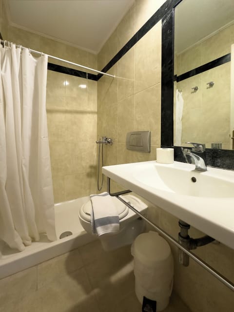 Bathtub, towels, shampoo, toilet paper