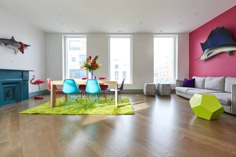 Spacious and colorful open-concept living area with bold decor, large windows, and vibrant design 🎨🪟 Ideal for entertaining, bachelorette parties, or group celebrations!  🤩🎉🥳👰 Natural light and fun vibes throughout!