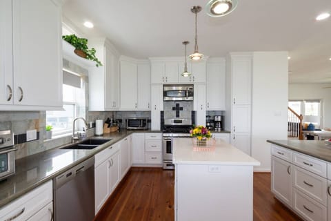 The kitchen features stainless steel appliances, white cabinets and quartz countertops.