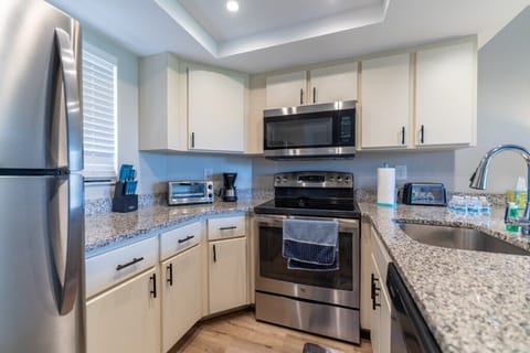 Modern kitchen equipped with stainless steel appliances and granite countertops.