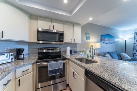 Modern kitchen with stainless steel appliances and sleek granite countertops.