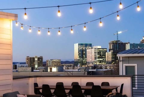 Rooftop deck with string lights, dining area and seating