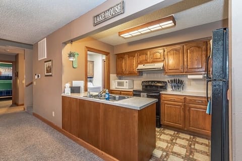 Kitchen with view into back room with washer/dryer and second fridge/freezer