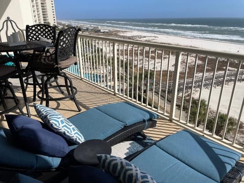 Large balcony with two chaise lounges and bar height table for four