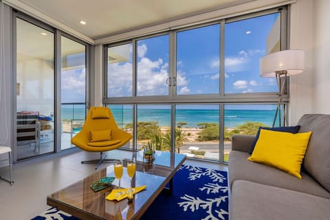 Unwind in this bright living room where floor-to-ceiling windows frame stunning turquoise ocean views and soft coastal breezes drift through. Your own slice of paradise awaits.